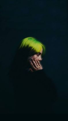 a woman with bright green hair in the dark