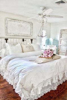 a white bed sitting in a bedroom on top of a hard wood floor