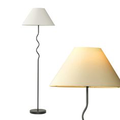 a lamp with a white shade on it next to a black and white floor lamp