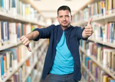 a man in a library giving the thumbs up