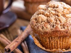 a muffin sitting on top of a blue napkin next to cinnamon sticks