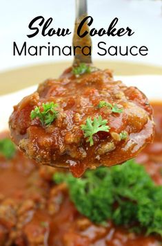 a spoon full of meatballs and sauce with parsley on the top is held up by a fork