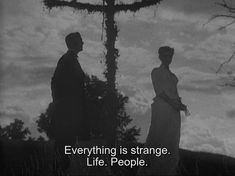 two people standing in front of a cross with the words everything is strange life, people