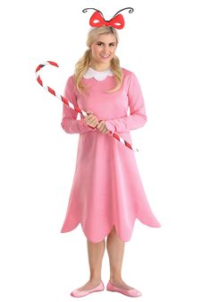 a woman in pink dress holding two candy canes