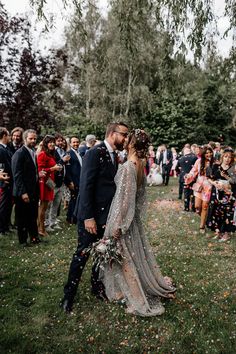 a bride and groom are kissing in front of confetti as they walk down the aisle