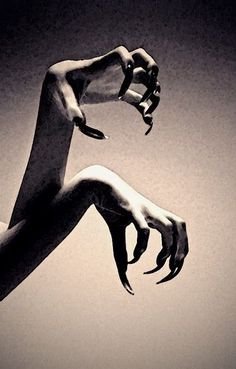 a black and white photo of a hand reaching up into the air