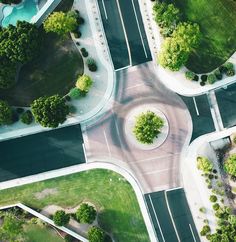 an aerial view of a street intersection in the middle of a park with lots of trees