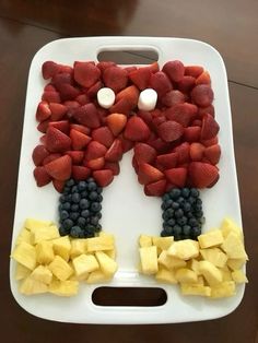 a tray with fruit cut into the shape of a man