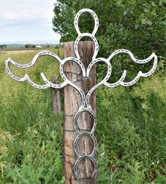 a metal cross sitting on top of a wooden post