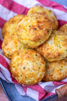 some crab cakes are on a plate with a red and white checkered cloth next to a knife