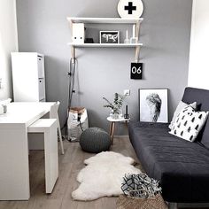 a living room with grey walls and white furniture in the corner, including a black couch