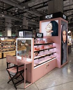 the inside of a cosmetics store with pink counter tops and display cases for makeup products