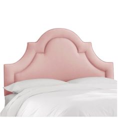 an upholstered headboard on a bed with white linens and pillows,