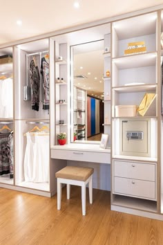 a white dressing room with wooden floors and shelves