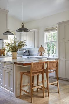 a kitchen with two stools and an island