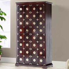 a wooden cabinet with many doors and flowers on the front, sitting in a living room