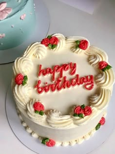 a birthday cake with white frosting and red roses on the top that says happy birthday