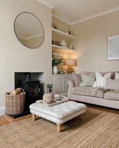 a living room filled with furniture and a fire place under a mirror on the wall