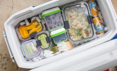 a cooler filled with lots of food on top of a floor next to a wall