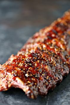 a piece of meat covered in ketchup and seasoning sitting on top of a table