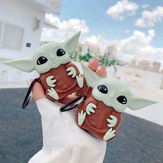 two little baby yoda cell phones are held up in the palm of someone's hand