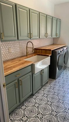 a washer and dryer in a kitchen with green cabinets