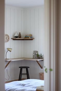 a bedroom with a desk and shelves on the wall