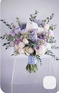 a bouquet of flowers sitting on top of a white table next to a window sill