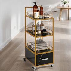 a gold and black shelf with some bottles on it's sides in a white room