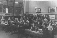 an old black and white photo of children sitting at desks