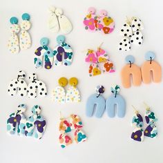 several pairs of earrings are displayed on a white surface with polka dots and butterfly shapes