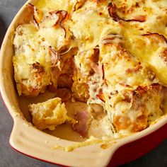 a casserole dish with ham, cheese and bread in it on a table