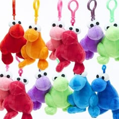 several different colored stuffed animals hanging from hooks