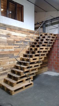 some stairs made out of wooden pallets next to a brick wall