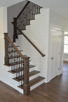 a staircase in a house with white walls and wood floors