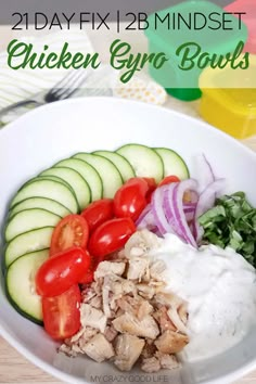 a white bowl filled with chicken, cucumber, tomatoes and other veggies