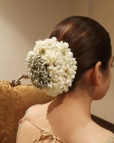 a woman with flowers in her hair sitting on a couch