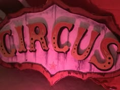 a sign that says circus on it in front of a red and pink background with stars