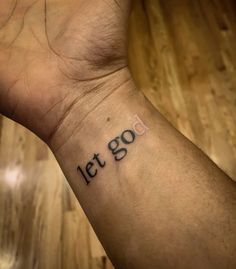 a wrist tattoo with the words let go written on it