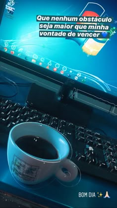 a cup of coffee sitting in front of a computer monitor