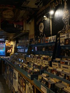 the inside of a music store with many records on shelves and posters hanging from the ceiling