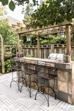 an outdoor bar with four stools under a pergolated trellis on the patio