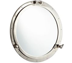 a mirror that is on the side of a white wall and has metal frame around it