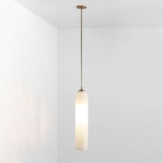 a light fixture hanging from the ceiling in a room with white walls and flooring