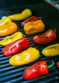 several peppers are cooking on a grill with the words mozzarella stuffed sweet mini peppers