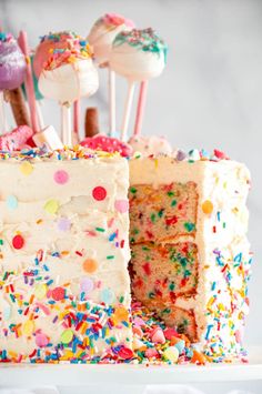 a birthday cake with sprinkles and lollipops on top