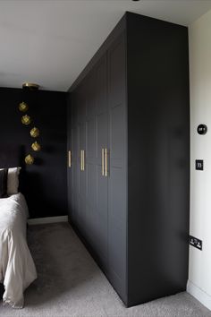 a black and white bedroom with gold accents on the headboard, closets, and bed