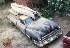 an old car with a surfboard on top of it