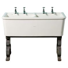 a white sink with three faucets on it