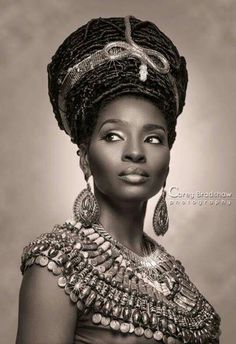 an african woman wearing a headdress and jewelry